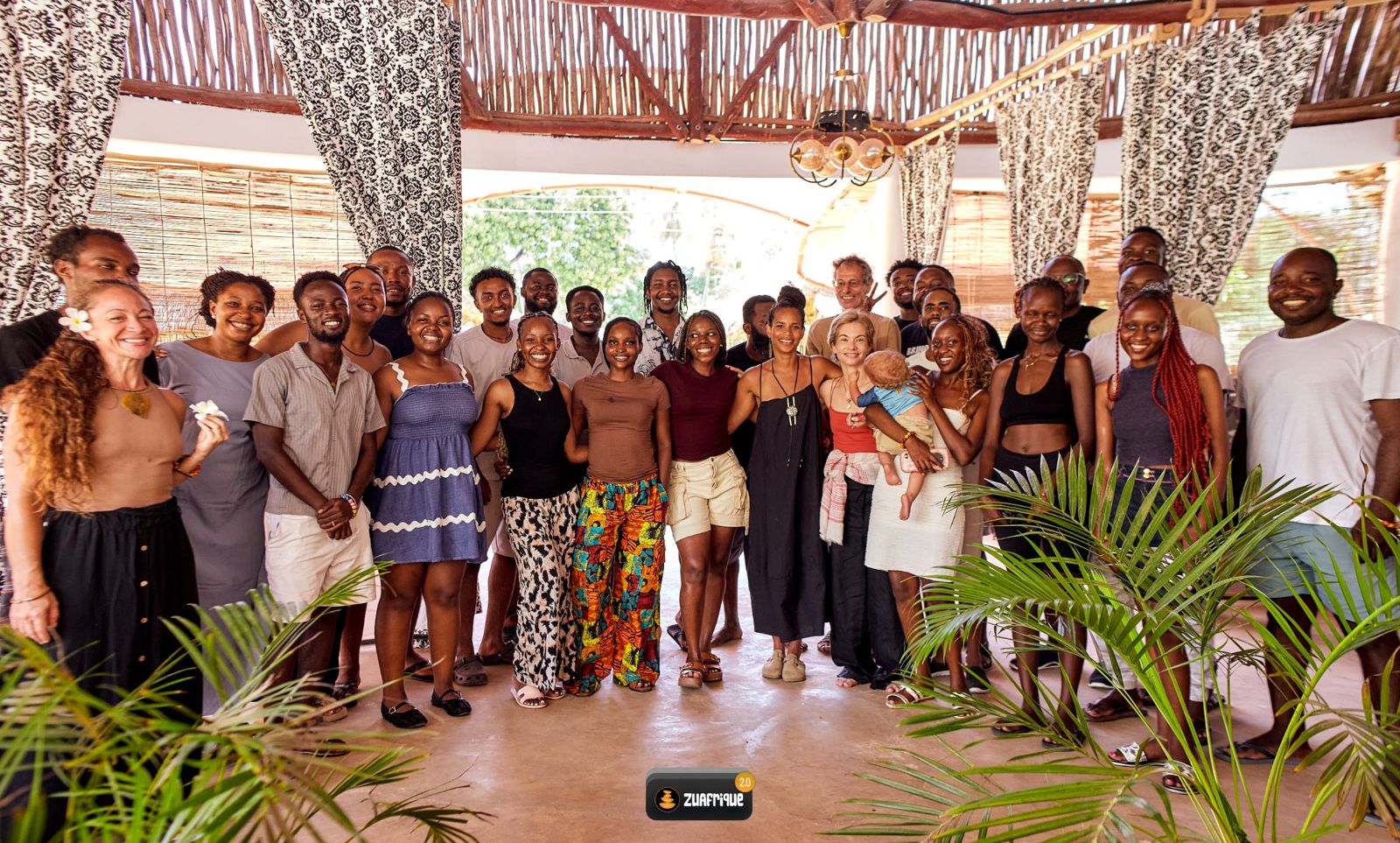 The 2026 residents, from nine countries, standing together and smiling in the open-air hall at Kilifi.